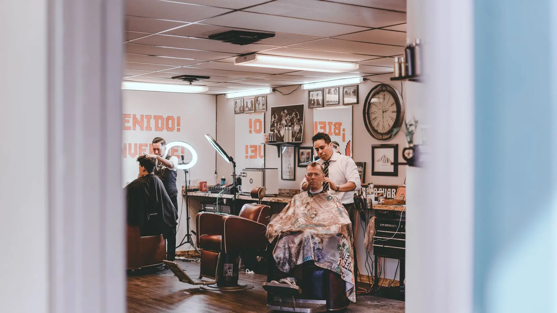 Barbeiro finalizando um corte de cabelo na barbearia